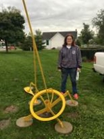 Artist Kathy Pizzo standing next to her sculpture Apollo